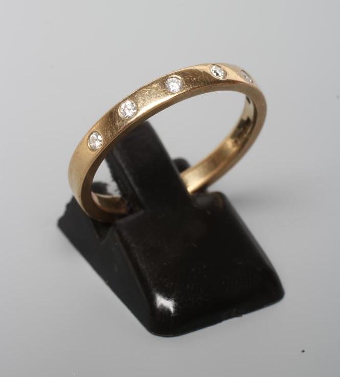 A DIAMOND SET WEDDING RING, the plain 9ct gold band gypsy set with six brilliant cut stones, Image
