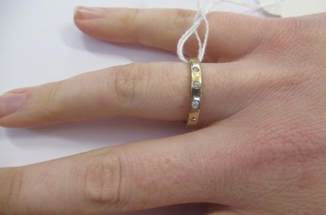 A DIAMOND SET WEDDING RING, the plain 9ct gold band gypsy set with six brilliant cut stones, Image