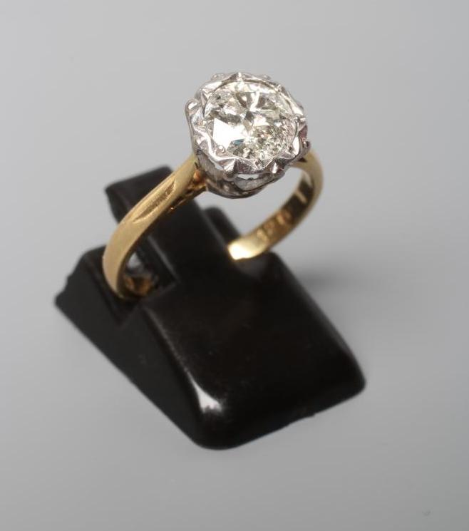 A SOLITAIRE DIAMOND RING, the old cut stone of approximately 1ct, open back collet set to a plain Image