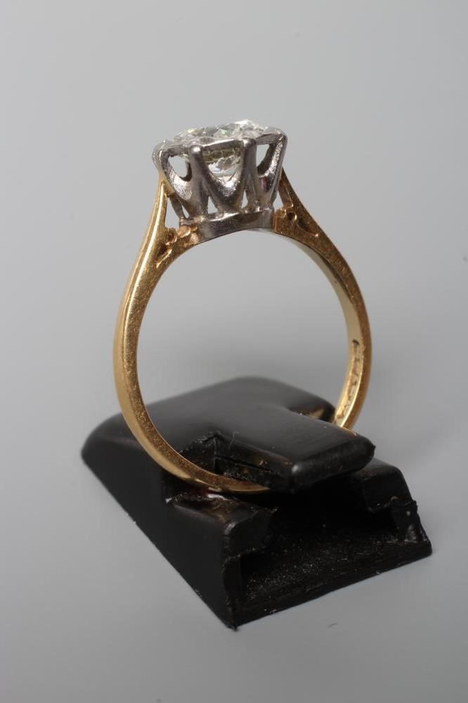 A SOLITAIRE DIAMOND RING, the old cut stone of approximately 1ct, open back collet set to a plain Image