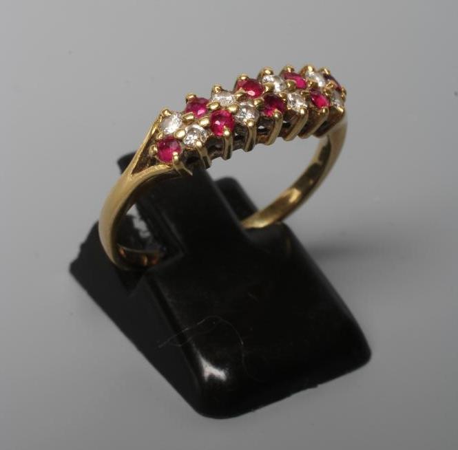 A RUBY AND DIAMOND DRESS RING, point set with eight each rubies and diamonds to a plain 18ct gold Image
