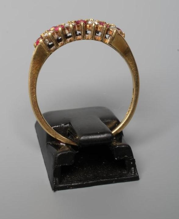 A RUBY AND DIAMOND DRESS RING, point set with eight each rubies and diamonds to a plain 18ct gold Image