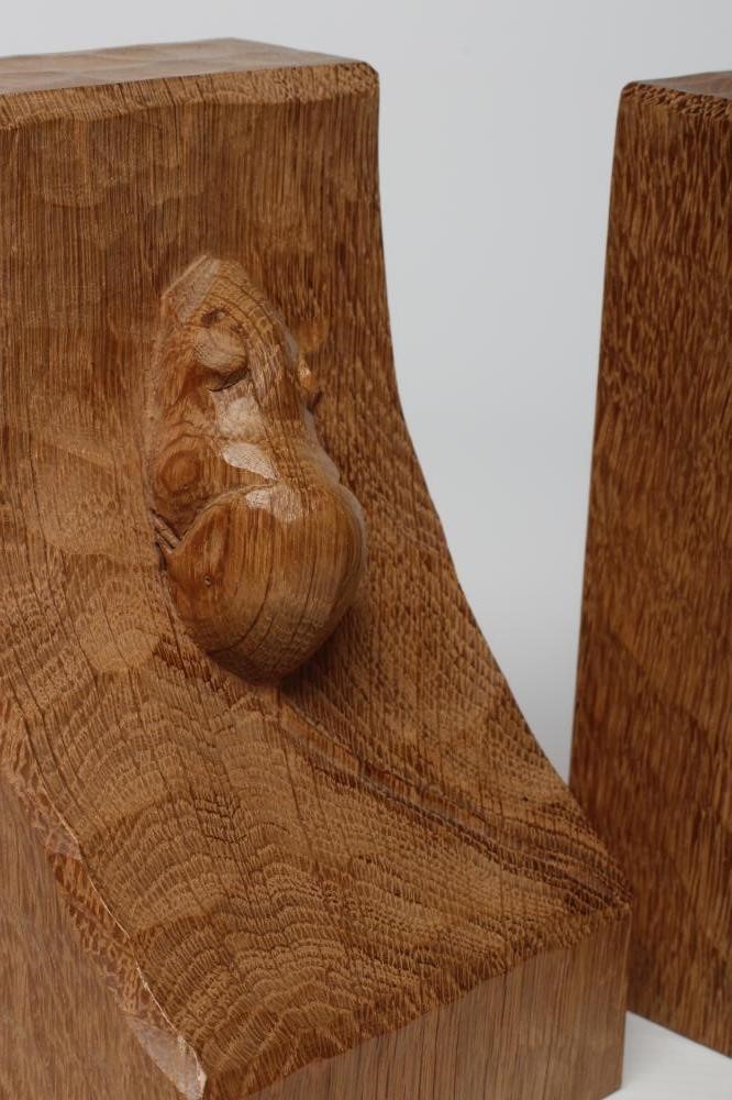 A PAIR OF ROBERT THOMPSON ADZED OAK BOOKENDS of dished square form with carved mouse trademark in Image