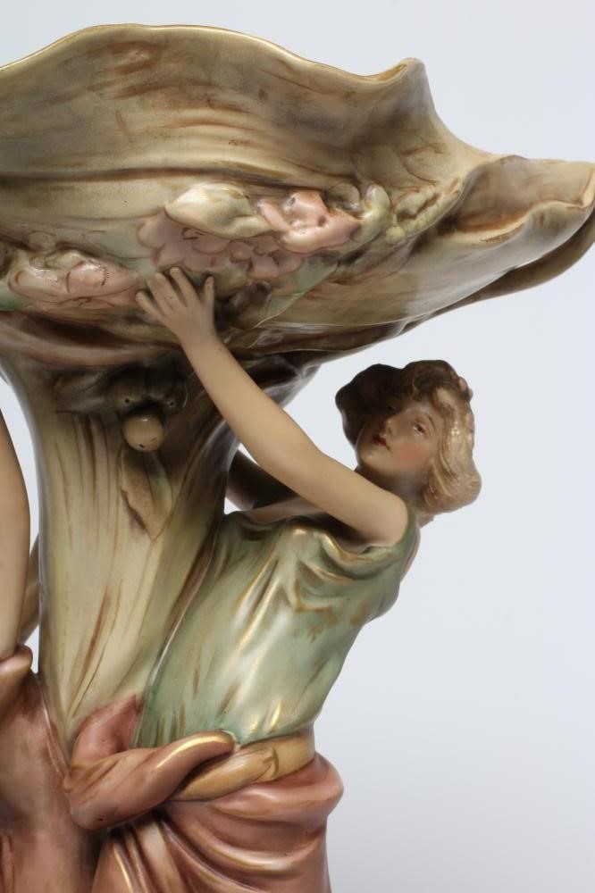 A ROYAL DUX PORCELAIN ART NOUVEAU FIGURAL CENTREPIECE modelled as two young maidens holding aloft a Image