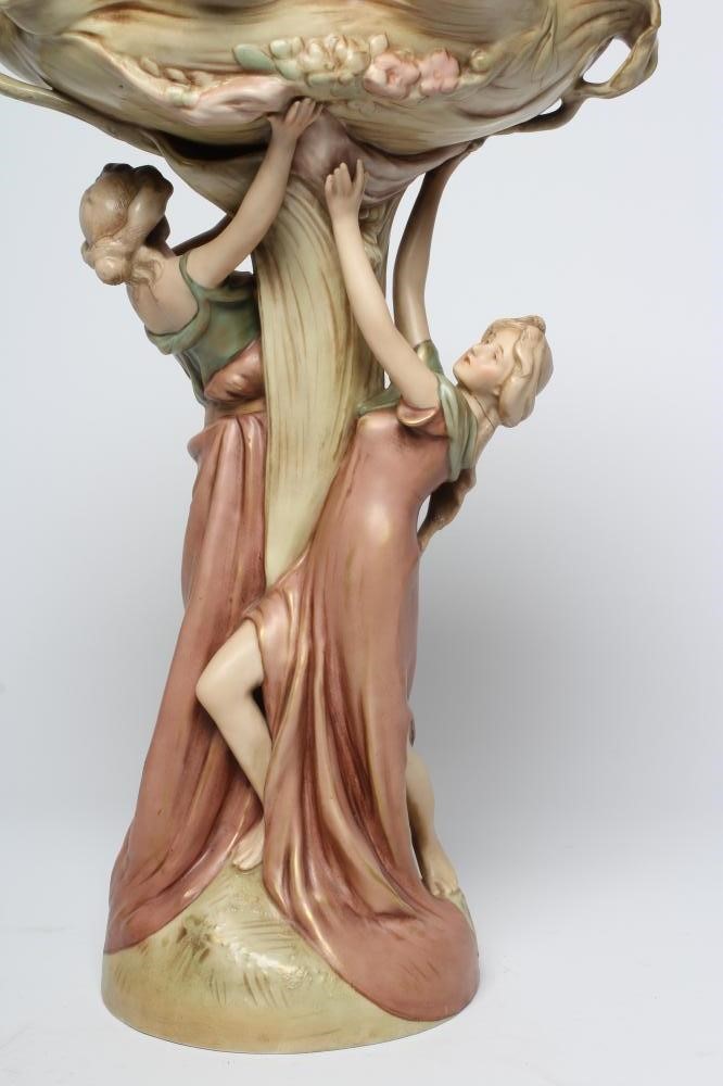 A ROYAL DUX PORCELAIN ART NOUVEAU FIGURAL CENTREPIECE modelled as two young maidens holding aloft a Image
