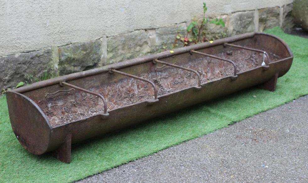 A CAST IRON TROUGH of long narrow oblong form with five raised bar divides, on square section end Image