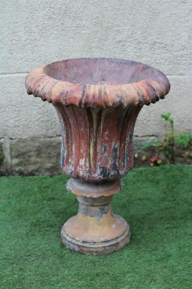 A TERRACOTTA URN, the moulded waisted body with similar everted rim, on turned socle, 22" x 28 1/2" Image