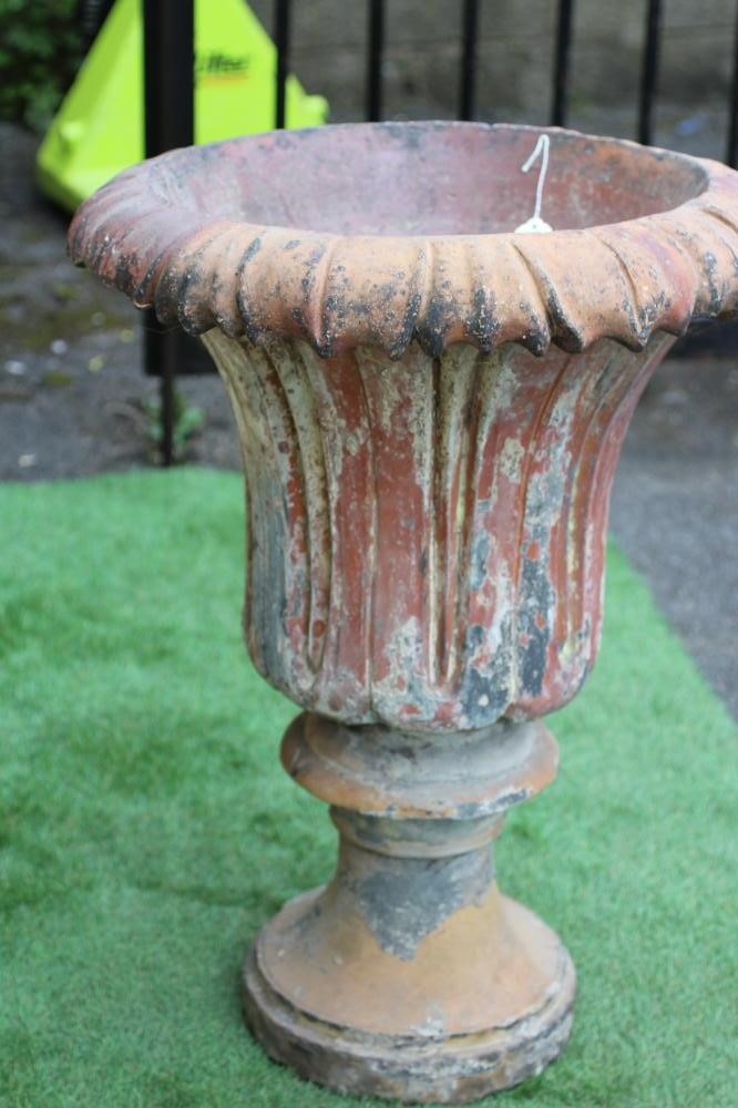 A TERRACOTTA URN, the moulded waisted body with similar everted rim, on turned socle, 22" x 28 1/2" Image