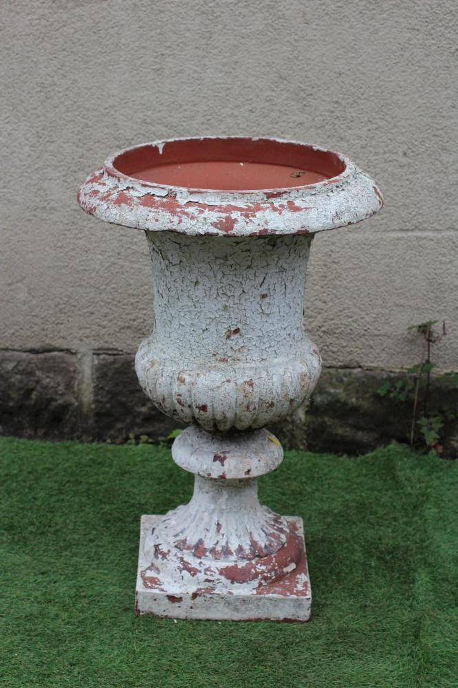 A TERRACOTTA URN of half fluted campana form with plain rim, fluted socle and square base, 20 1/2" x Image