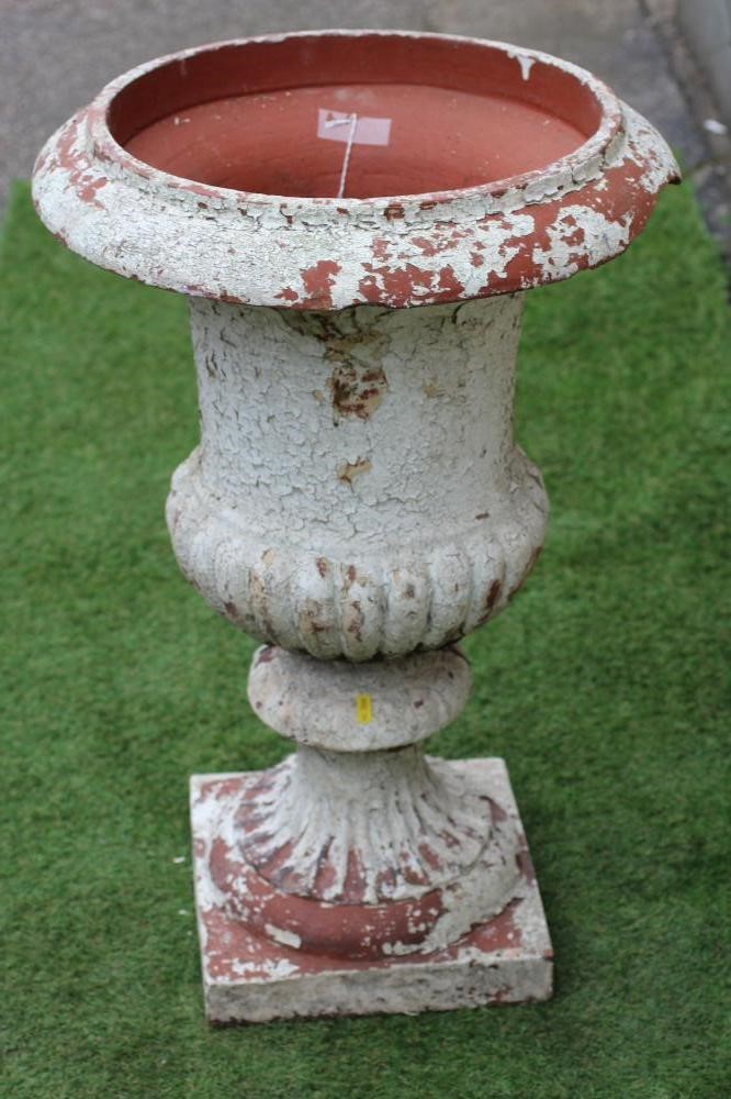 A TERRACOTTA URN of half fluted campana form with plain rim, fluted socle and square base, 20 1/2" x Image