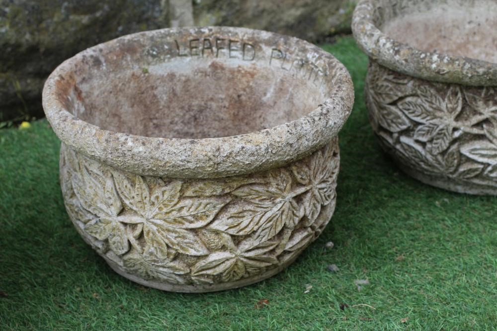 A SET OF THREE CAST STONE CIRCULAR PLANTERS with leaf moulded sides, 14 1/4" x 9", together with a Image