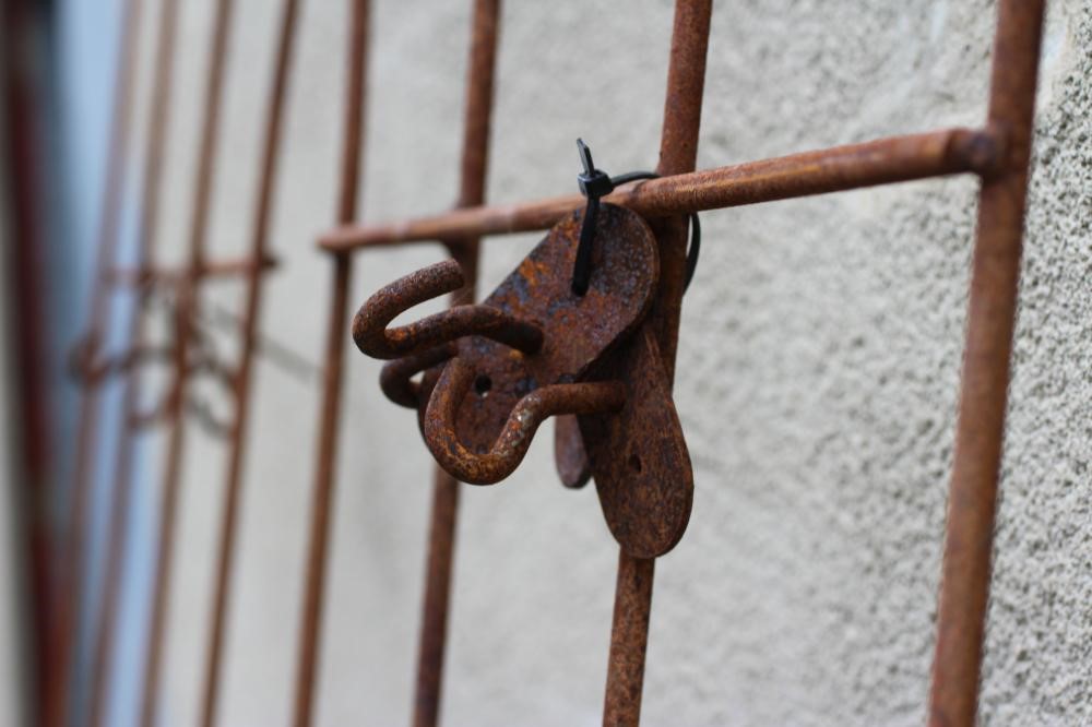 A PAIR OF HAND FORGED WROUGHT IRON WALL PLANT SUPPORTS of splayed outline with ball finials, 23 - 29 Image