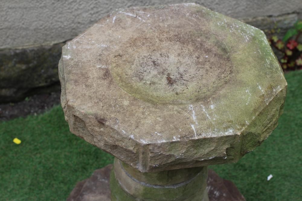 A SANDSTONE BIRDBATH, the octagonal bowl on sectional disc stem and stepped base, 24" x 26 1/4" Image