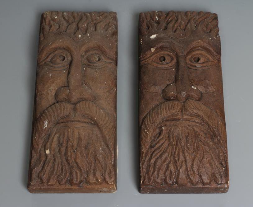 A PAIR OF CARVED SANDSTONE GREEN MAN WALL MASKS of shallow oblong form, stained brown, 13 1/2" x 5 Image