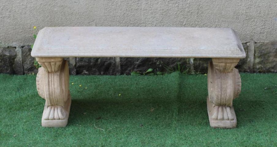 A CAST STONE BENCH, the moulded edged oblong top on scrolled end supports, 44 1/4" x 15 1/2" x 18" Image