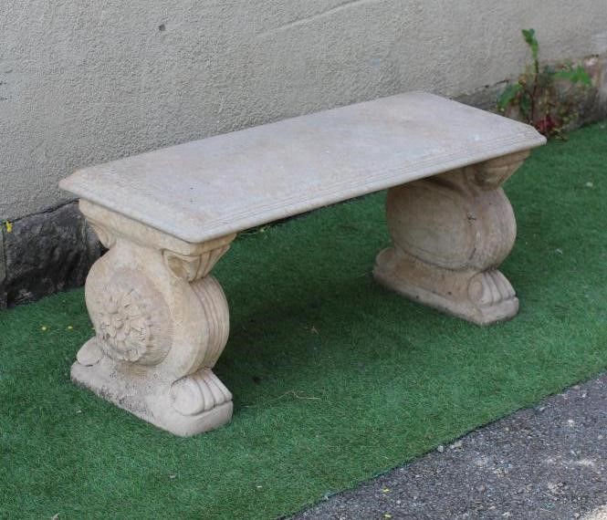 A CAST STONE BENCH, the moulded edged oblong top on scrolled end supports, 44 1/4" x 15 1/2" x 18" Image