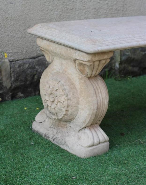 A CAST STONE BENCH, the moulded edged oblong top on scrolled end supports, 44 1/4" x 15 1/2" x 18" Image