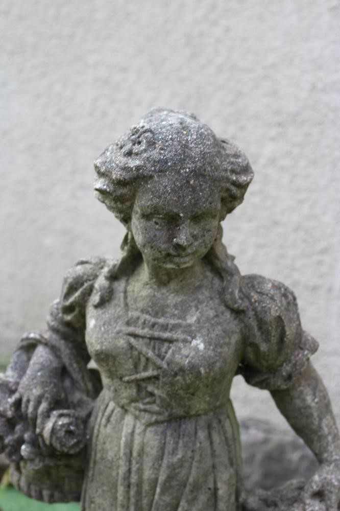 A PAIR OF CAST STONE ALLEGORICAL FIGURES of Summer and Autumn, raised on oblong base, 30" high (Est. Image