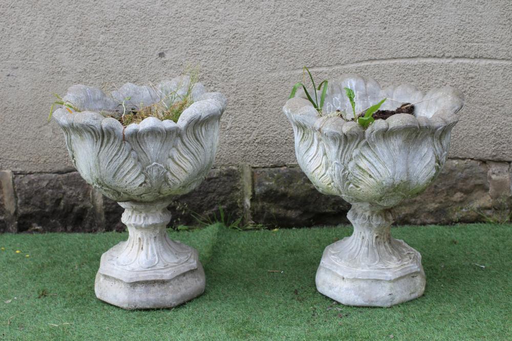 A PAIR OF CAST STONE URNS, the leaf moulded bowls on waisted socle with stiff leaf banding, 19 1/2" Image
