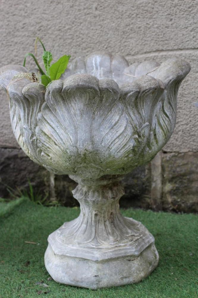 A PAIR OF CAST STONE URNS, the leaf moulded bowls on waisted socle with stiff leaf banding, 19 1/2" Image