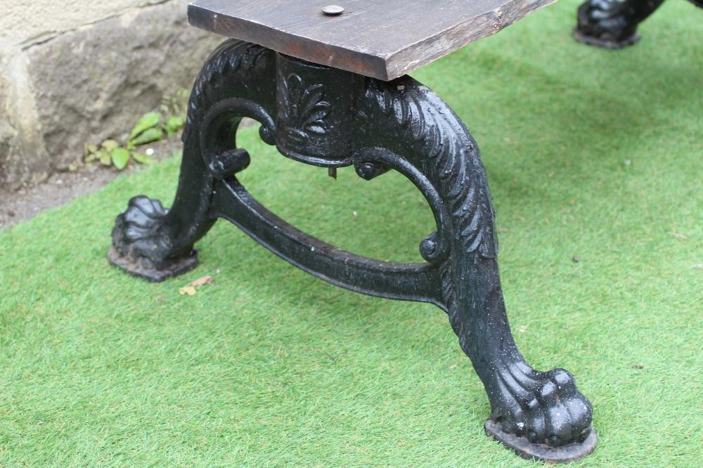 A CAST IRON DOUBLE SIDED GARDEN BENCH, the two scroll cast cabriole supports on paw feet, with later Image