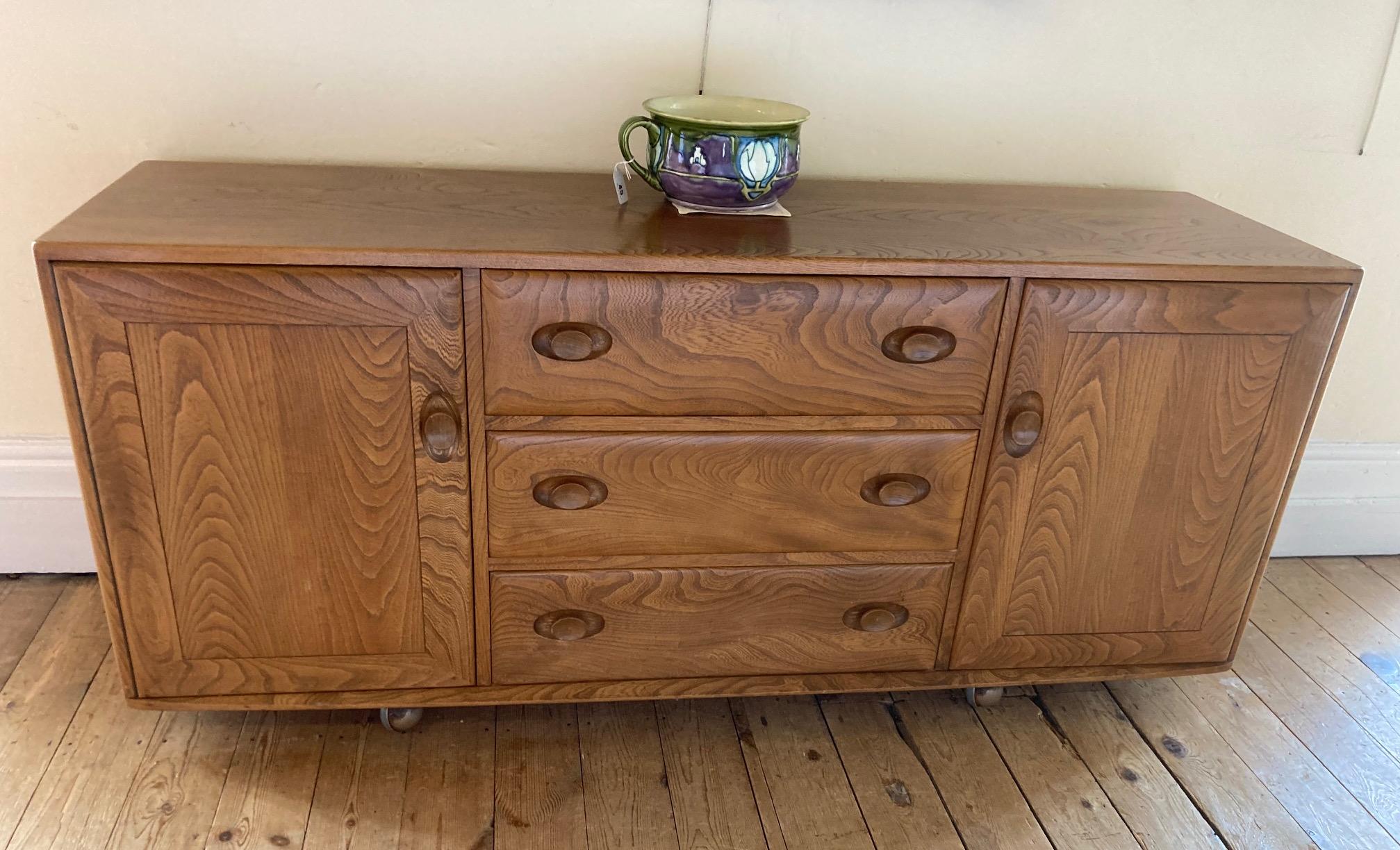 AN ERCOL LIGHT ELM SIDEBOARD, with three central drawers Image