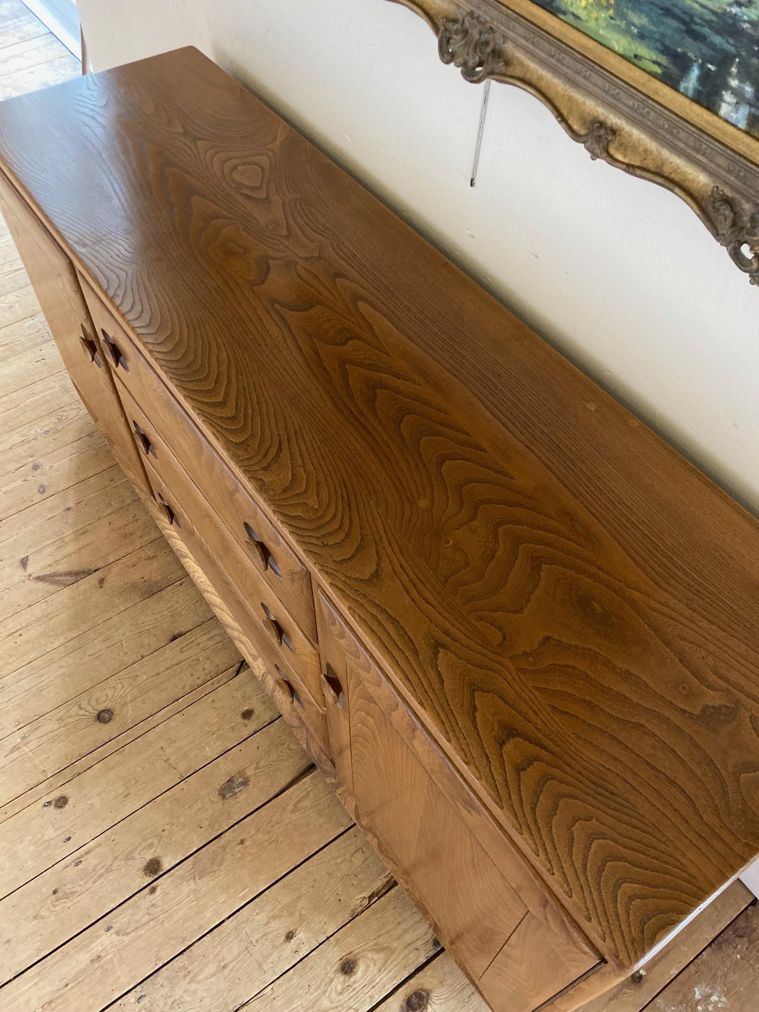 AN ERCOL LIGHT ELM SIDEBOARD, with three central drawers Image