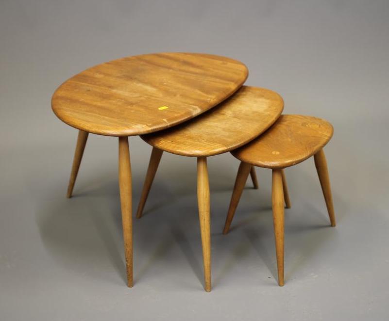 AN ERCOL NEST OF THREE PEBBLE TABLES, Model No.354, with elm top and beech legs, largest 19 3/4" Image