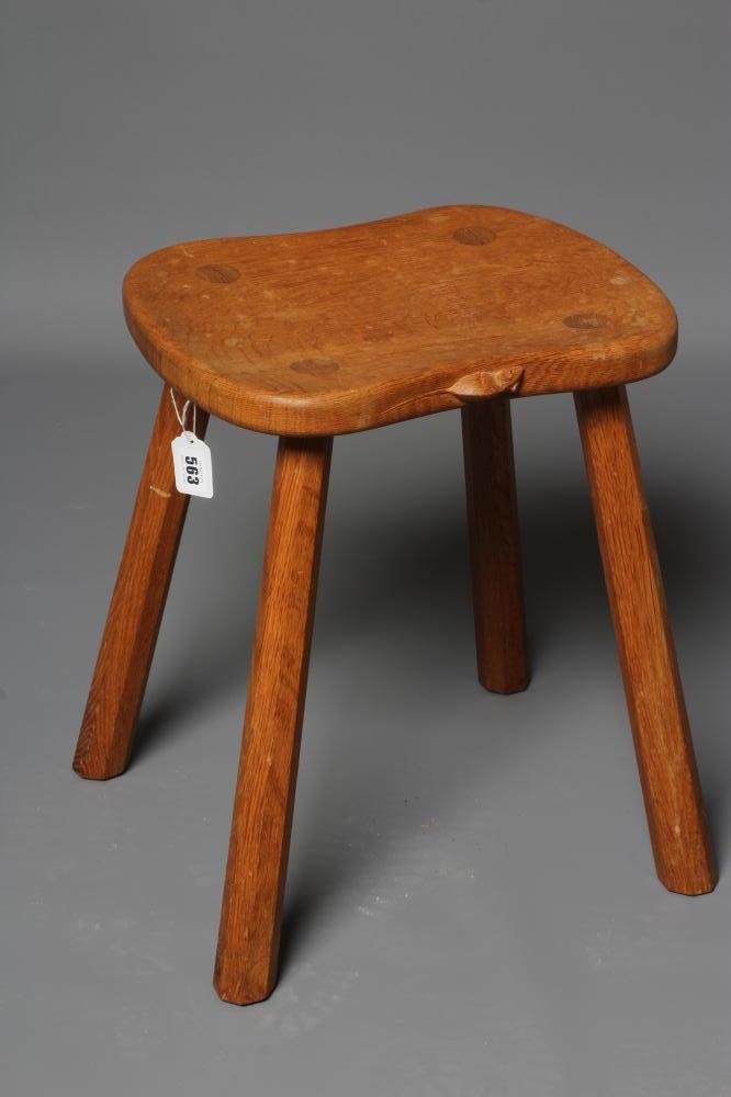 A ROBERT THOMPSON ADZED OAK STOOL of waisted rounded oblong seat raised on four faceted splayed legs Image