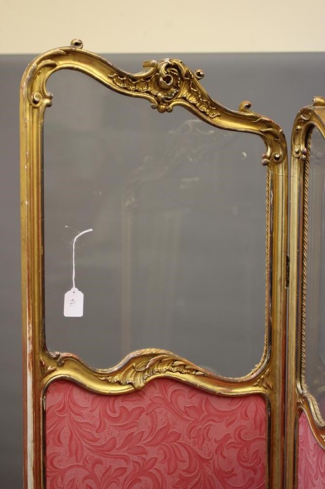 A VICTORIAN GILTWOOD FOLDING ROOM SCREEN in the rococo style carved with rocaille and foliate Image