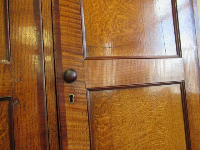 A LARGE GEORGIAN OAK AND MAHOGANY BANDED HOUSEKEEPERS CUPBOARD Image