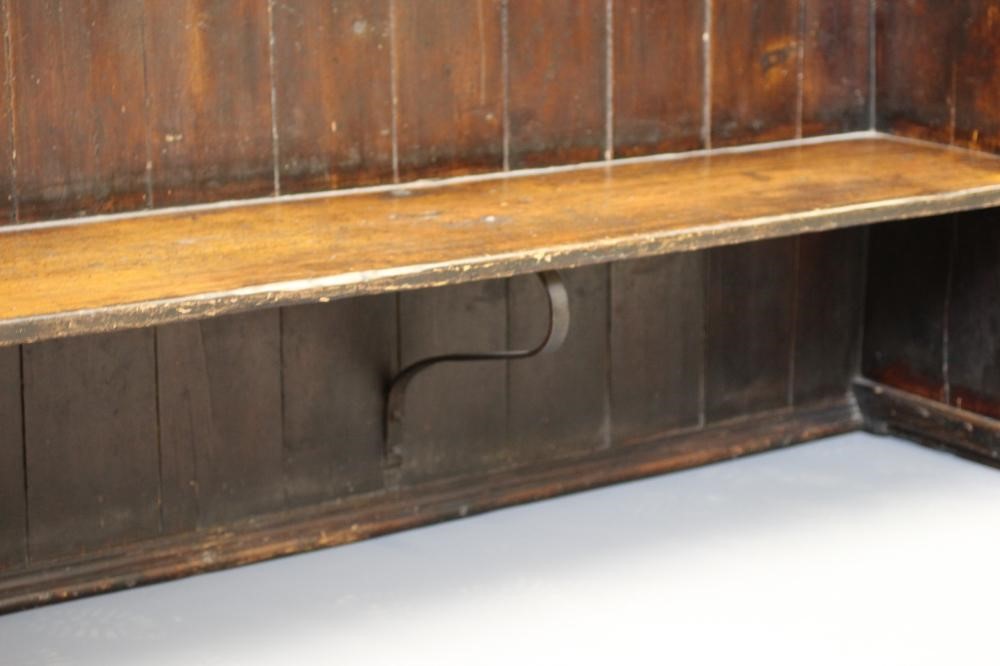 A STAINED PINE WING BACK TAVERN SETTLE, 19th century, with high boarded back, plank seat with Image