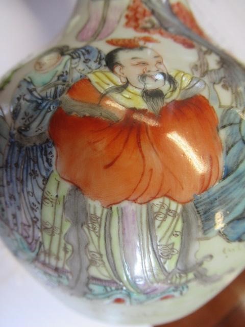 A CHINESE PORCELAIN BOTTLE VASE painted in colours with a vignette of three figures below a gnarled Image