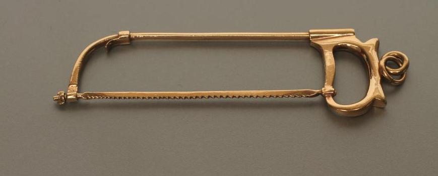 A 9CT GOLD NOVELTY HACKSAW PENDANT Image