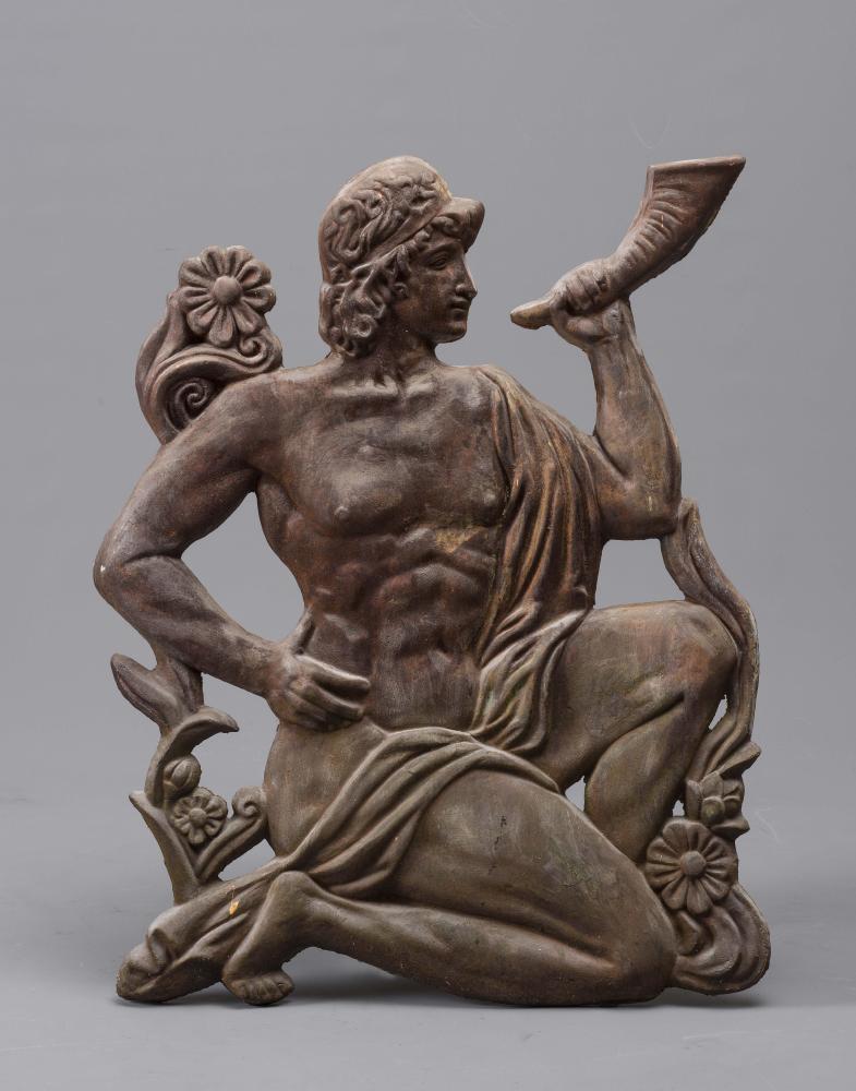 AN ART DECO CAST IRON WALL APPLIQUE modelled as a classical semi-nude youth bending down on one knee Image