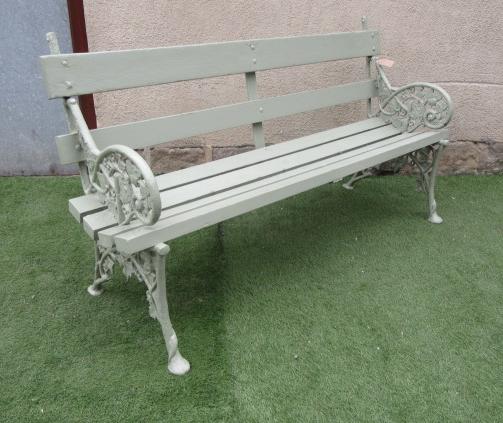 A CAST IRON GARDEN BENCH with slatted wood back and seat Image