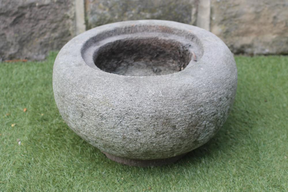 A SMALL GRITSTONE TROUGH of circular tapering form with incurving rim Image