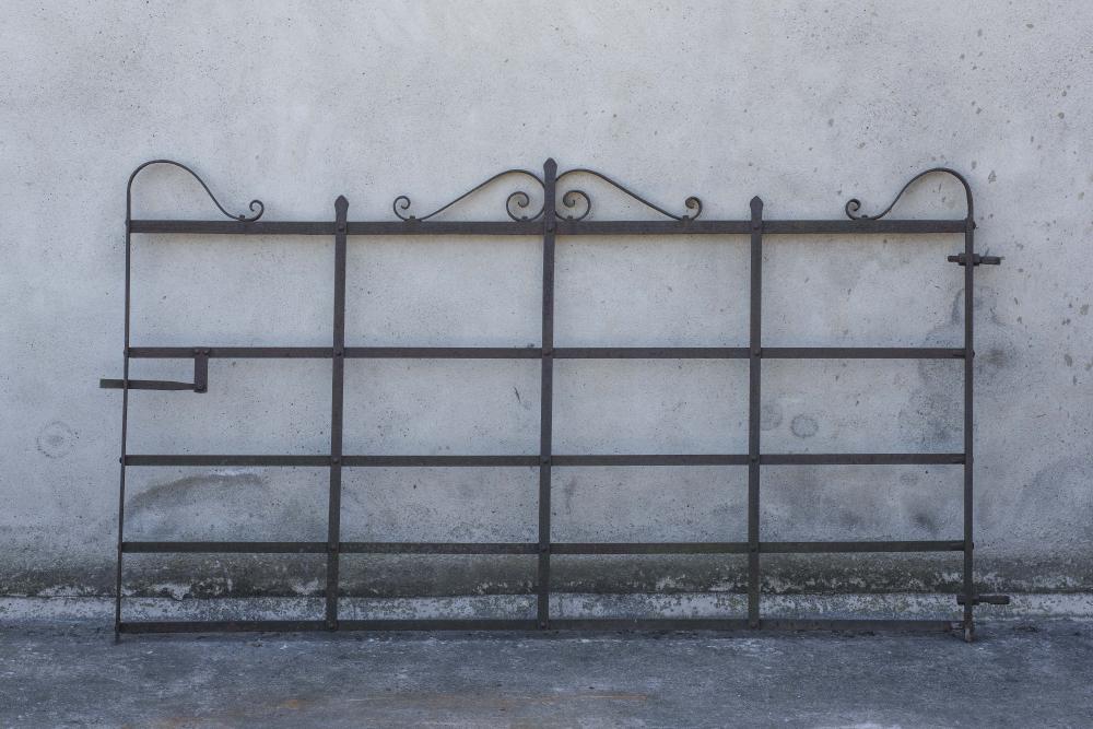 A WROUGHT IRON FIVE BAR GATE with scrolled surmount Image