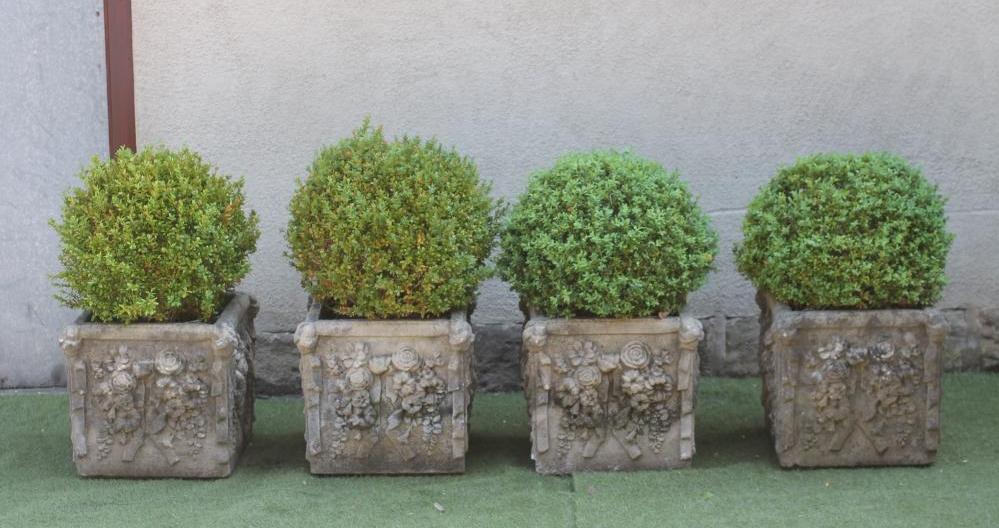 A SET OF FOUR COMPOSITION STONE PLANTERS of square form moulded with flowers in high relief Image