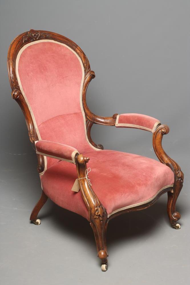A VICTORIAN WALNUT FRAMED ARMCHAIR of spoonback form carved with foliage and upholstered in pink Image