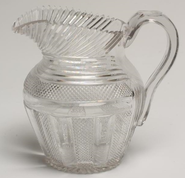 A GEORGIAN WATER JUG of baluster form with slice and strawberry cut panels below slice cut shoulders Image