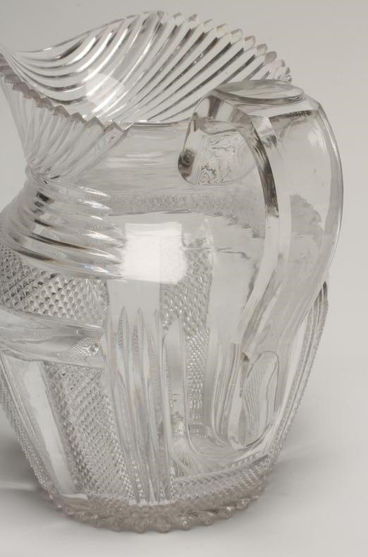 A GEORGIAN WATER JUG of baluster form with slice and strawberry cut panels below slice cut shoulders Image