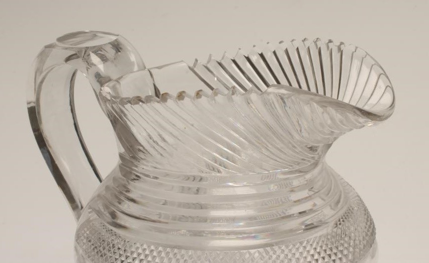 A GEORGIAN WATER JUG of baluster form with slice and strawberry cut panels below slice cut shoulders Image