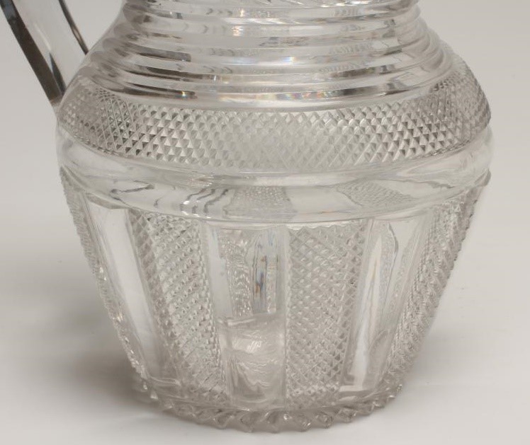 A GEORGIAN WATER JUG of baluster form with slice and strawberry cut panels below slice cut shoulders Image