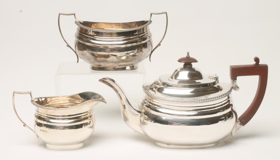 A MATCHED AND COMPOSITE SILVER THREE PIECE TEA SERVICE Image