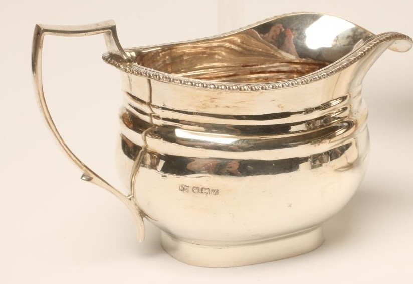 A MATCHED AND COMPOSITE SILVER THREE PIECE TEA SERVICE Image