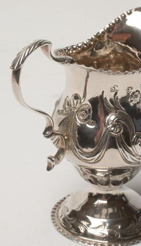 A GEORGE III SILVER CREAM JUG Image