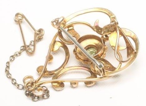AN EDWARDIAN PERIDOT AND SEED PEARL BROOCH/PENDANT of open scrolling heart form Image