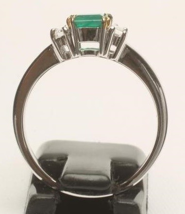 AN EMERALD AND DIAMOND THREE STONE RING Image