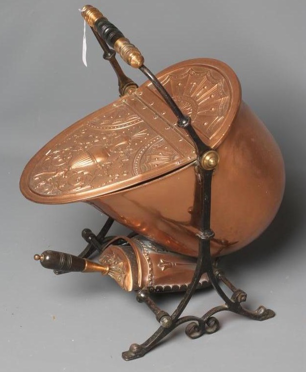 A VICTORIAN COPPER COAL SCUTTLE of helmet form raised on an open scroll work Image